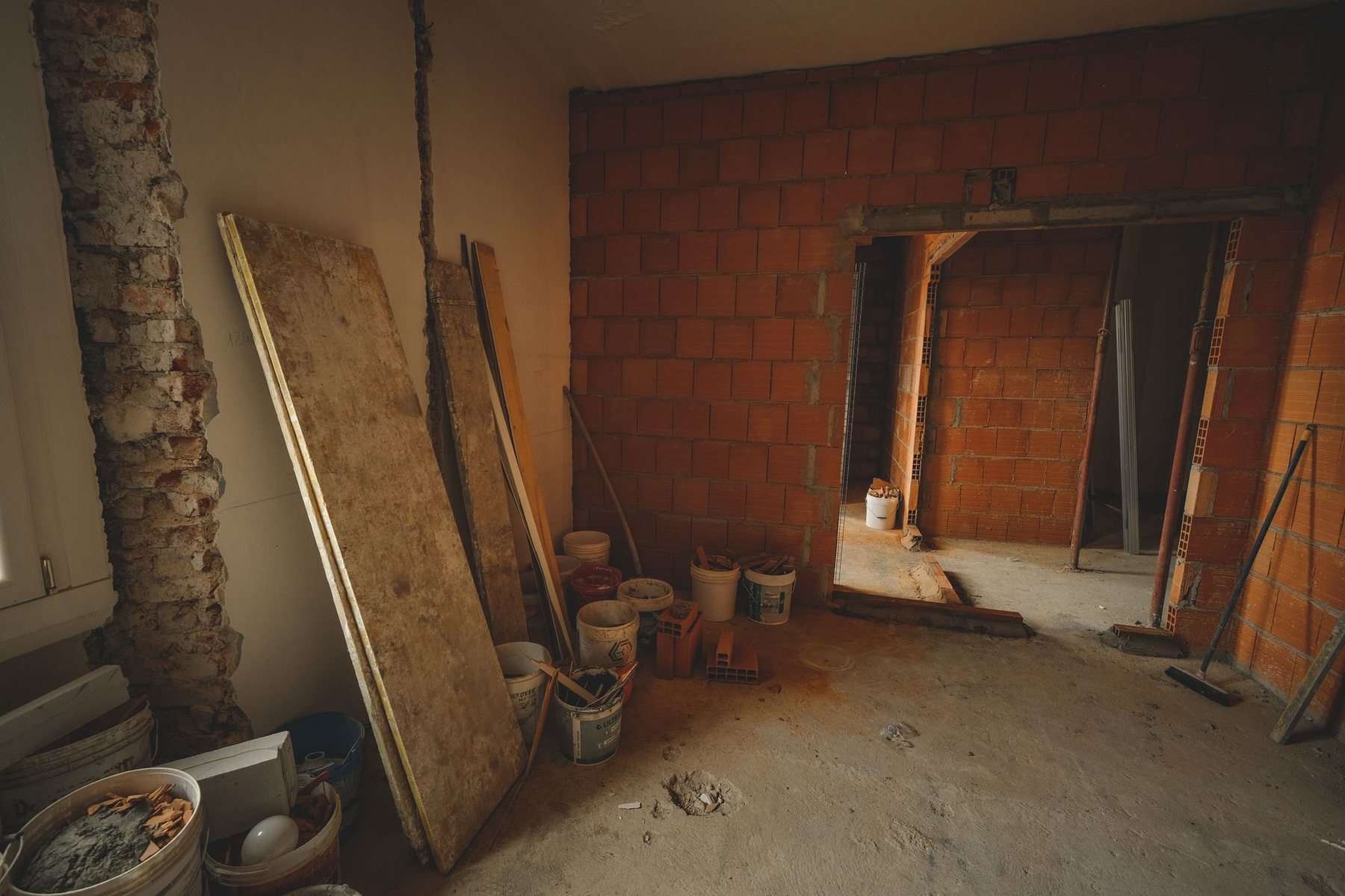 Interior de una ampliación en obra gruesa, con muro de ladrillo a la vista